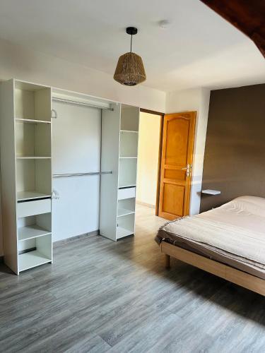 Au Cosy في Guînes: غرفة نوم بسرير ورفوف وخزانة