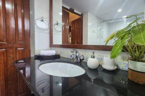 een badkamer met een wastafel en een spiegel bij Stelliam's Luxury Heritage Suite in Campal, Goa in Panaji