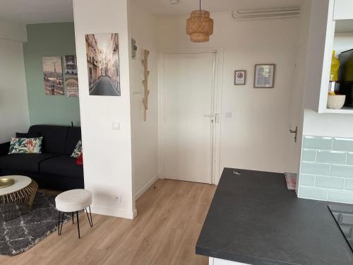 a living room with a couch and a table at 2 pièces lumineux aux portes de Paris in Clamart