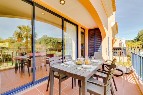 a dining room with a table and chairs on a balcony at AL - Apartamento Vila Sol N in Vilamoura