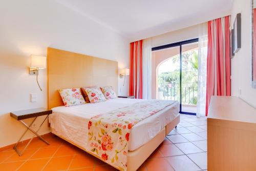 a bedroom with a bed and a large window at AL - Apartamento Vila Sol N in Vilamoura