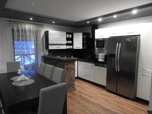 uma cozinha com uma mesa de jantar e um frigorífico em Mieszkanie na Flo em Florynka