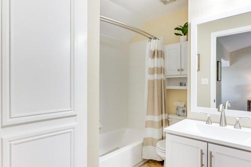 La salle de bains blanche est pourvue d'un lavabo et d'une douche. dans l'établissement Lovely Monkey Island Getaway Pool and Lake Access!, à Afton