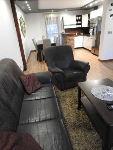 uma sala de estar com um sofá, cadeiras e uma mesa em Mieszkanie na Flo em Florynka
