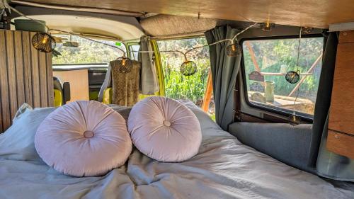 two pillows sitting on a bed in an rv at Unique 70s stay! Volkswagen T2 Campervan Dome in Castelldefels