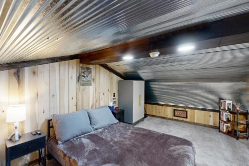 Un dormitorio con una cama en una habitación con paredes de madera. en Fins N Fowl, en Tiptonville