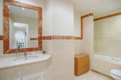 a bathroom with a sink and a toilet and a mirror at Mar y Puerto Best Location by Sol Maestranza in Marbella