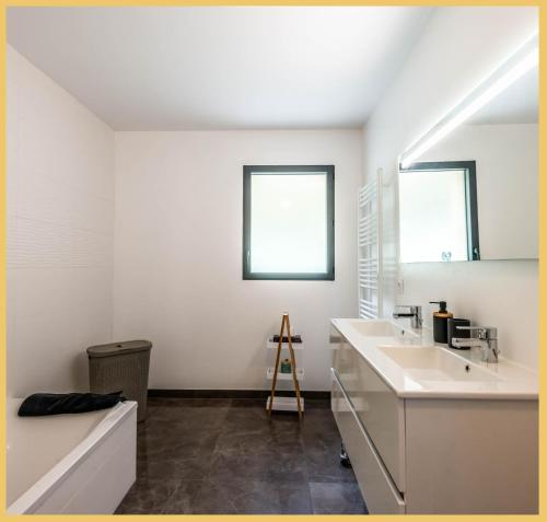 een witte badkamer met 2 wastafels en een spiegel bij Chic Vanilla Home, Entre Annecy et Genève in Cruseilles