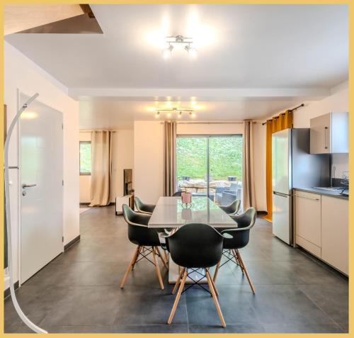 une cuisine et une salle à manger avec une table et des chaises dans l'établissement Chic Vanilla Home, Maison moderne entre Annecy et Genève, à Cruseilles