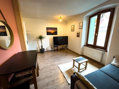 a living room with a couch and a tv at T2 centre Ville Proche des pistes in Briançon