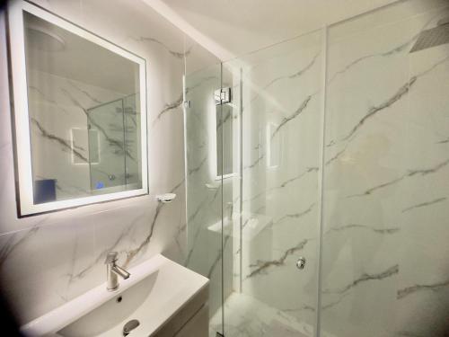 a bathroom with a glass shower and a sink at Amplio apartamento renovado con 3 habitaciones, 3 baños, terrazas, Smart TV y wifi incluidos in Caracas