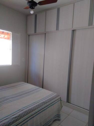 a bedroom with white walls and a bed in it at Duplex na Praia de Guriri in São Mateus