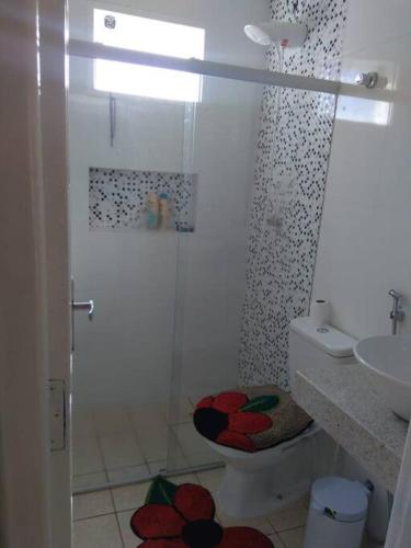 a bathroom with a shower with a toilet and a sink at Duplex na Praia de Guriri in São Mateus