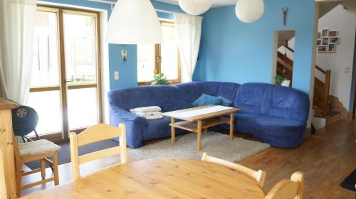 a living room with a blue couch and a table at Calm House in suburbs of Cracow in Michałowice