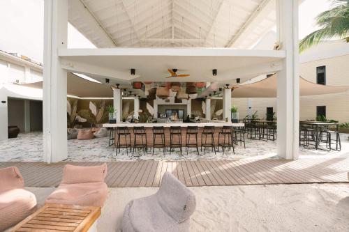 an outdoor patio with a bar with chairs and tables at Papagayo Beach Hotel in Willemstad