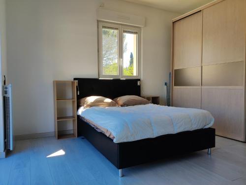 une chambre avec un grand lit et une fenêtre dans l'établissement Agréable studio 1 avec piscine au calme absolu, à Cabriès
