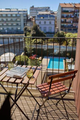 a table and chairs on a balcony with a view at Oporto Maison Anselmo in Porto