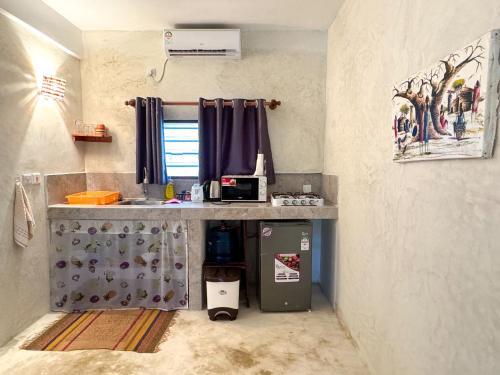 a kitchen with a counter with a sink and a refrigerator at Kaleb's Beachfront Studios in Malindi