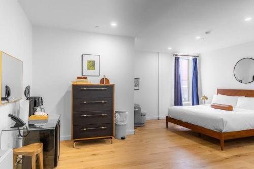 a bedroom with a bed and a dresser and a desk at King Bed, Historic DTWN Hotel, Coffee Shop, Room # 202 in Bangor