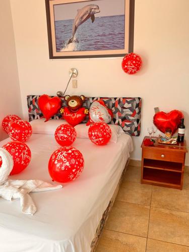 a bed with red heart balloons on it at Stefany's Lodging in Puerto Baquerizo Moreno