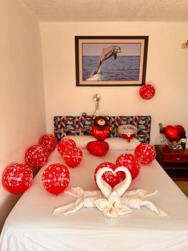 a bed with red pillows and hearts on it at Stefany's Lodging in Puerto Baquerizo Moreno