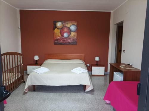 1 dormitorio con 1 cama y una pintura en la pared en B & B Villa Lucia, en Noci