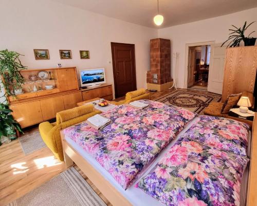 a bedroom with a large bed with a floral blanket at Apartment in a historical house in the center of Levoča in Levoča