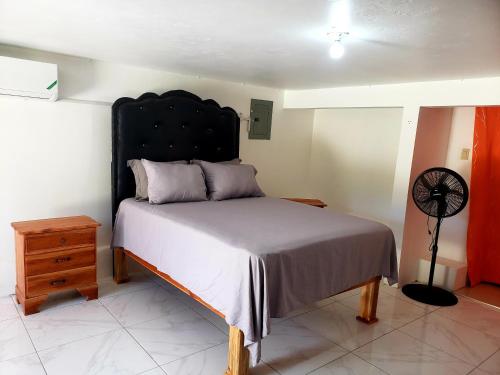 a bedroom with a bed with a black headboard at Cozy Apartment Greenwood in Montego Bay