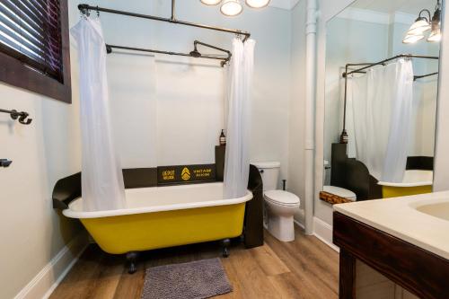 a bathroom with a yellow tub and a toilet at Depot Village in Gainesville