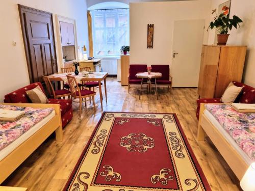 a living room with two beds and a dining room at Apartment in a historical house in the center of Levoča in Levoča