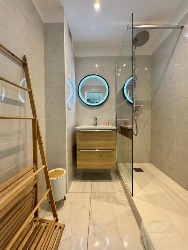 une salle de bain avec une douche, un lavabo et un miroir dans l'établissement Villa D'Este - Apt 4 prs - clim - 300m plage - piscine-parking en option, à Juan-les-Pins