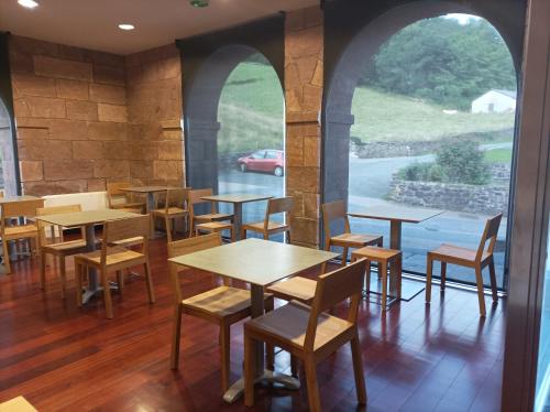 a dining room with tables and chairs and a window at Hotel Jauregi Borda in Maya del Baztán