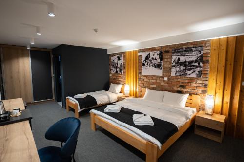 um quarto de hotel com duas camas e uma parede de tijolos em Velkov Apartments em Vinica