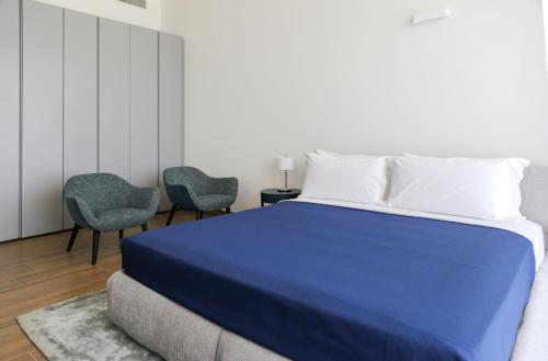a bedroom with a blue bed and two chairs at Heliconia Park Lagos Luxury Apartments in Lagos
