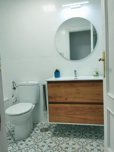 a bathroom with a toilet and a sink and a mirror at La Berrea Cabañaquinta in Aller