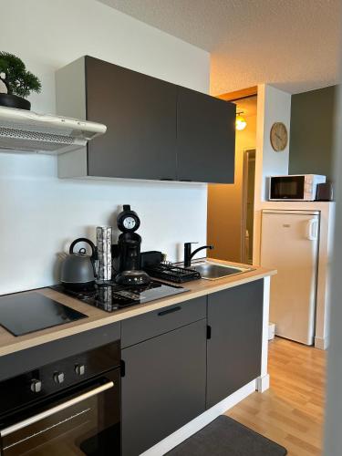 a kitchen with a sink and a stove top oven at Le soleil levant plage , casino, thalasso in Bénodet