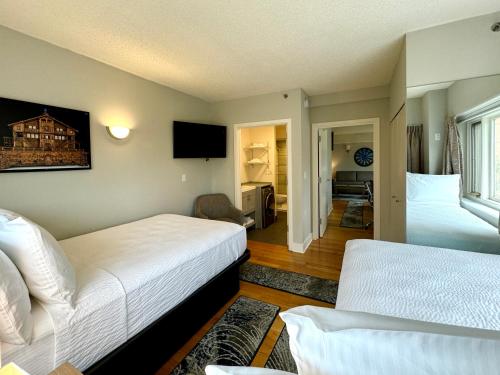 a bedroom with two beds and a living room at The GEM Museum Suites in Evanston