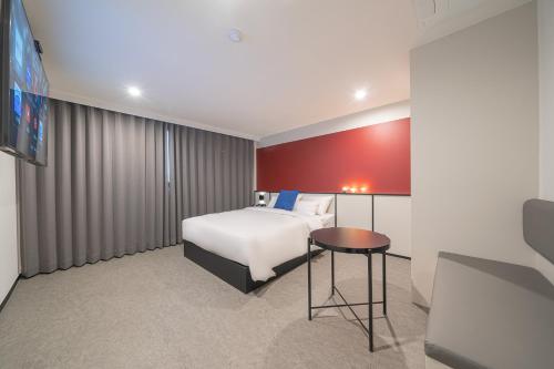 um quarto de hotel com uma cama e uma mesa em Hotel Lavanda em Incheon