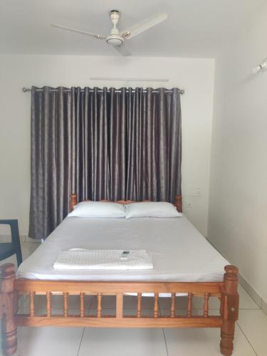 Ce lit se trouve dans un dortoir doté d'une fenêtre. dans l'établissement Laasya Comforts, à Mangalore