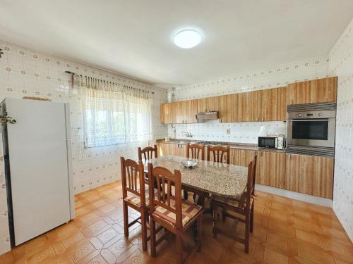 a kitchen with a table and chairs and a refrigerator at Casa Sear-Bordóns in Sear
