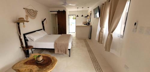 um pequeno quarto com uma cama e uma mesa em Pakáal Muliix - Naranjo em Mérida