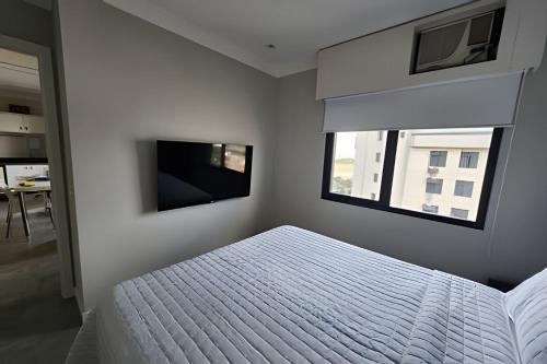 a bedroom with a white bed and two windows at Airfamily Congonhas in Sao Paulo