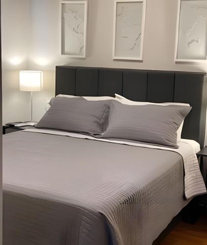 a bedroom with a large bed with a black headboard at Airfamily Congonhas in Sao Paulo