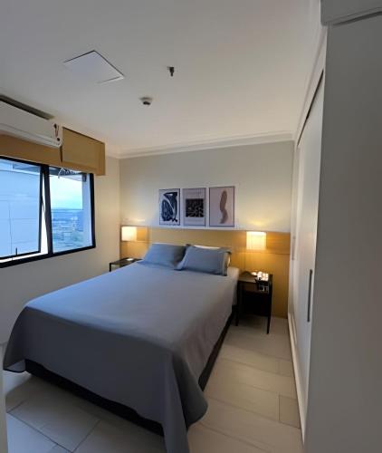 a bedroom with a large bed and a window at Airfamily Congonhas in Sao Paulo