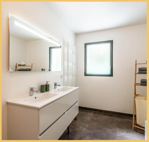 ein Badezimmer mit Waschbecken und Spiegel in der Unterkunft Zen Vanilla Home, Maison exotique entre Annecy et Geneve in Cruseilles