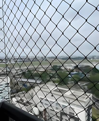 a view through a wire fence of a city at Airfamily Congonhas in Sao Paulo