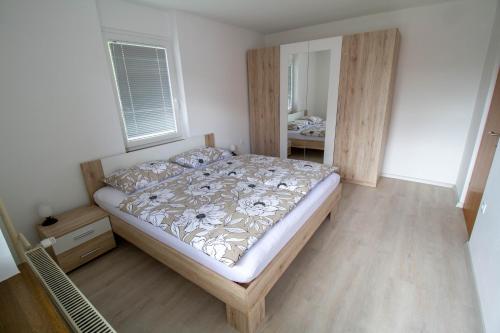 1 dormitorio con 1 cama con cabecero de madera en Apartma pri Klari, en Kočevje