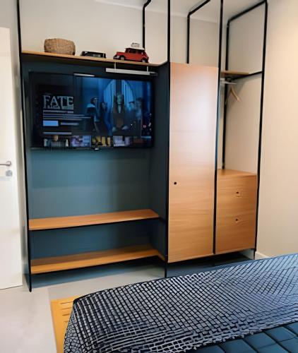 a wardrobe with a tv in a room at Airfamily Congonhas in Sao Paulo
