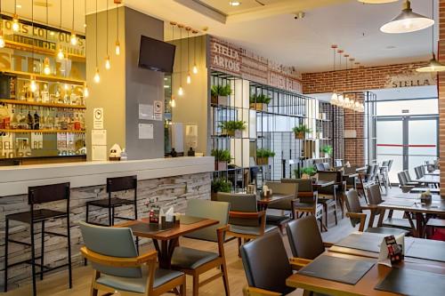 a restaurant with tables and chairs and a bar at Airfamily Congonhas in Sao Paulo