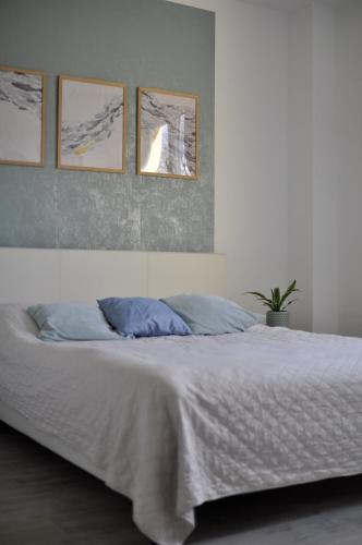 1 dormitorio con 1 cama con 4 cuadros en la pared en Apartament Verano, en Gdansk